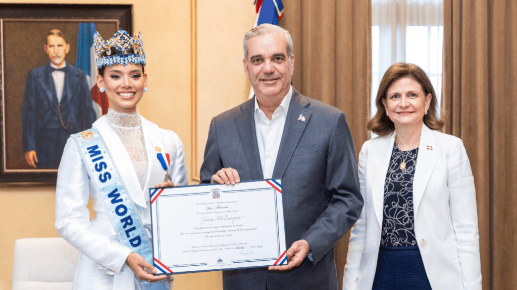 Ceremonia de entrega de reconocimiento a la ganadora de Miss Mundo, con el presidente y un funcionario presente.